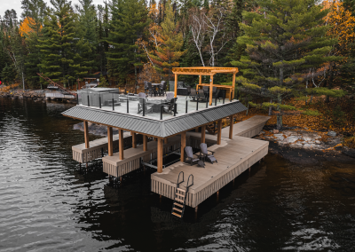 Aerial view of timber framed boathouse with rooftop gathering area.