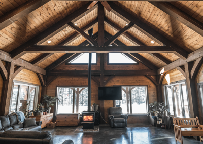 Timberframed room with fireplace and tv.