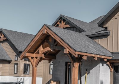 Full view of an in progress house with a timber entry.